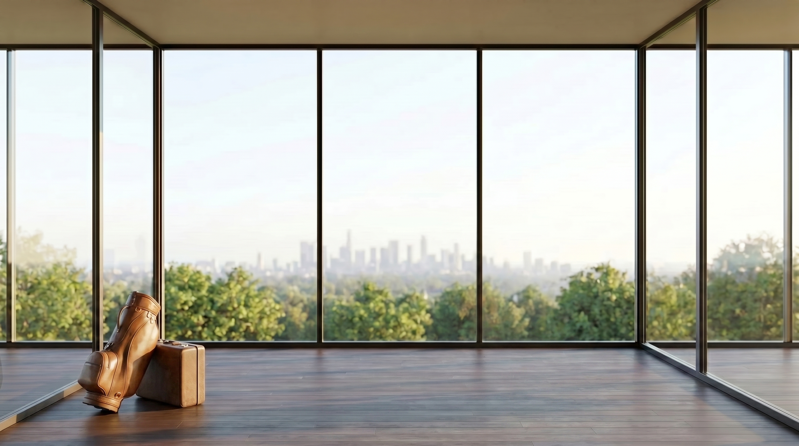 An empty high-rise corner room with dark-framed wrap-around glass, a leather golf bag and suitcase set in the left corner, green treetops and a hazy distant city skyline, dark timber floor.